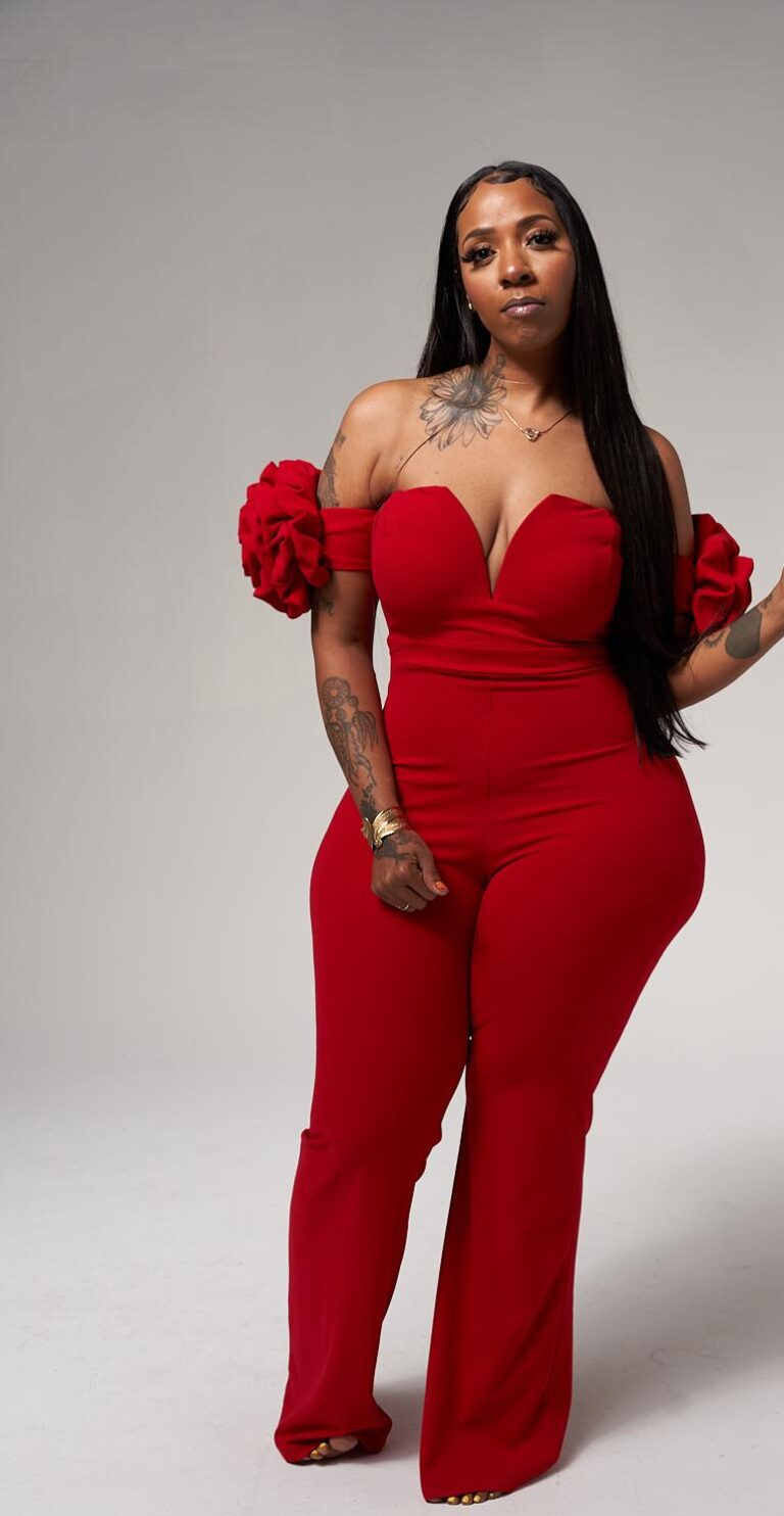 Nykima Metoyer in a red jumpsuit with long, sleek hair